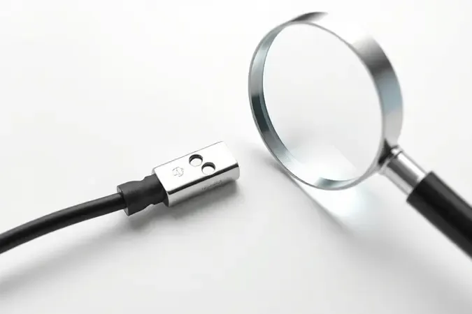 Crimpagem perfeita em fio elétrico com lupa de inspeção simbolizando controle de qualidade.