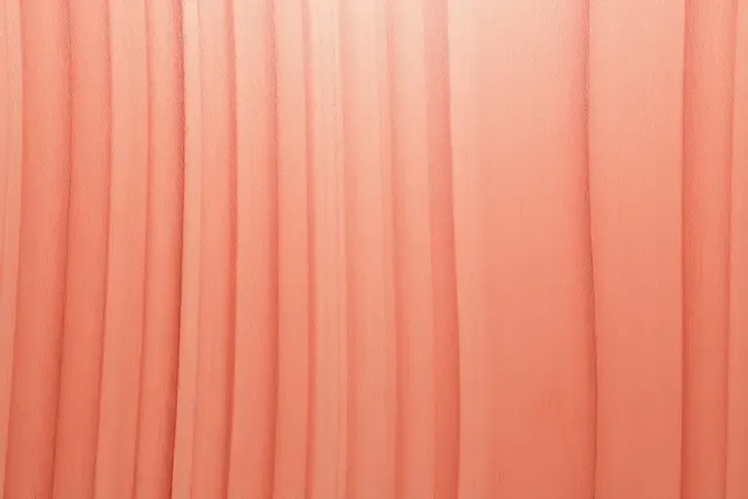Close conceitual de superfície de madeira com acabamento em verniz de tonalidade coral suave e textura refinada.